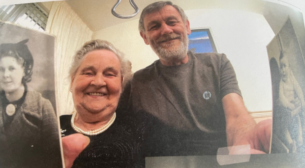 A photo of Molly and Ronnie French holding photos of their younger selves.